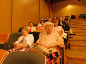 Widok gości konferencji siedzących w fotelach sali kinowej
