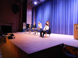 4 młodych ludzi na scenie, 3 z nich siedzi, jedno stoi - realizatorzy etiuda teatralna sztuki „Poczekalnia”