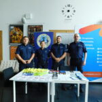 Policjanci Komendy Powiatowej Policji w Zduńskiej Woli przy stoliku tematycznym w holu Centrum Integracji Ratusz