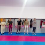 Uczestnicy warsztatów stoją w rzędzie na Sali Zduńskowolskiego Klubu Karate Kyokushin