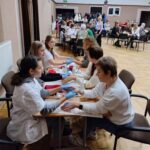 Uczniowie Zespołu Szkół Aktywności Zawodowej wykonują masaż rąk Seniorkom