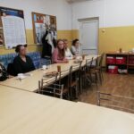 Panie studentki siedzą przy stolikach i słuchają prezentacji