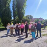 Seniorzy na spaceru historycznym, pan Tomasz Polkowski opowiada historię bloków, ich powstania