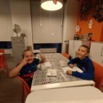 Chłopcy siedzą przy stoliku i pozują do zdjęcia