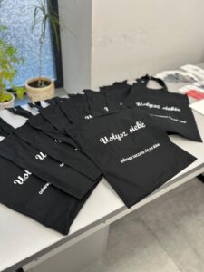 Zdjęcie przestawia torby bawełniane przeznaczone dla wszystkich uczestniczek projektu socjalnego z logo „Usłysz Siebie – odwaga zaczyna się od słów”