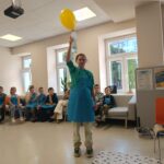 Dziewczynka trzyma w ręku butelkę z suchym lodem, która napełnia balon