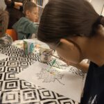 Dziewczynka w skupieniu nakłada roztwór z pipety na szablon z liściem