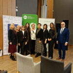 Grupa organizatorów stoi przy roll-upach