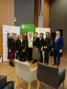 Grupa organizatorów stoi przy roll-upach