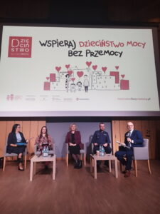 Pięć osób siedzi na fotelach i odpowiada na pytania prowadzącego