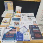 Stolik z ulotkami od ZUS, Policji i rzecznika finansowego dotyczące bezpieczeństwa