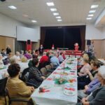 Seniorzy siedzą przy wspólnych stołach