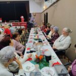 Seniorzy siedzą przy wspólnych stołach