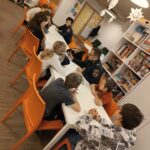 Dzieci rozmawiają z funkcjonariuszami o tym jak się bezpiecznie zachowywać podczas ferii.