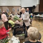 Dyrektor MOPSCOS rozdaje Seniorką kwiaty z okazji Dnia Kobiet